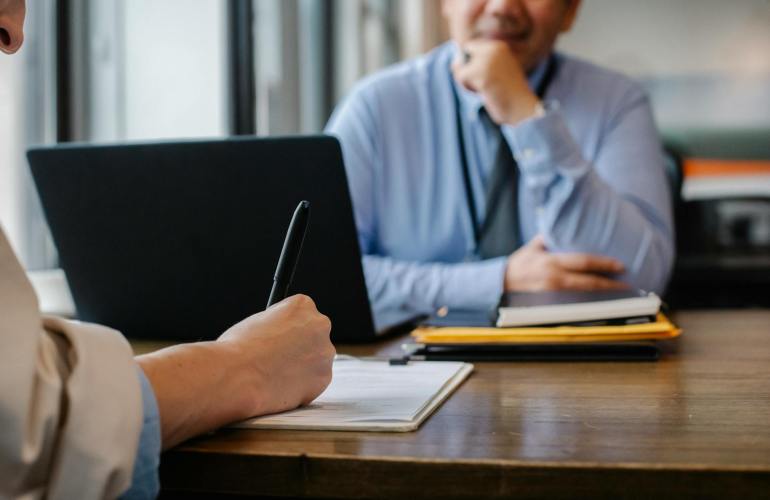 woman filling job application form in office with boss
